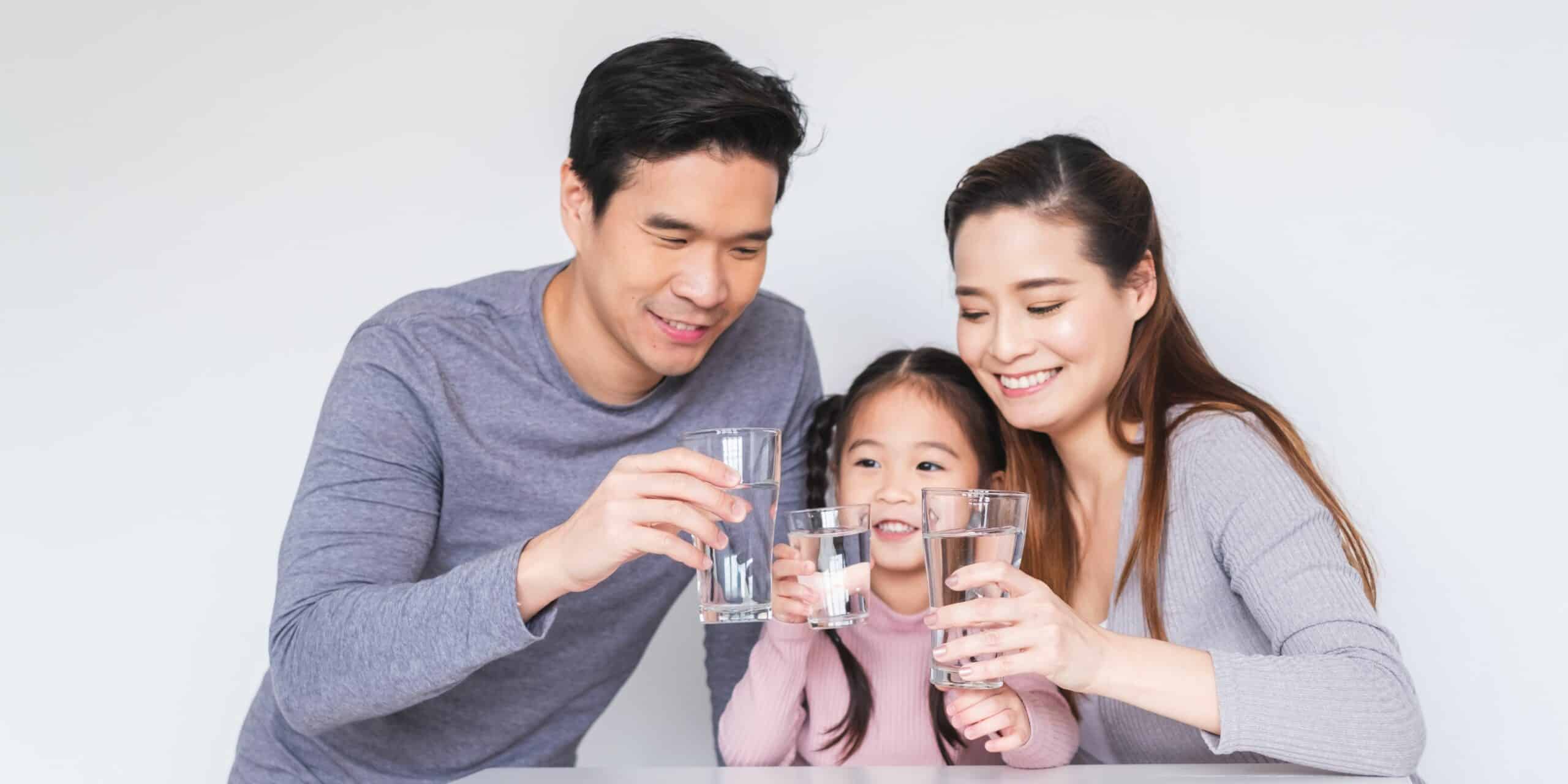 Happy family holding a glass of water.